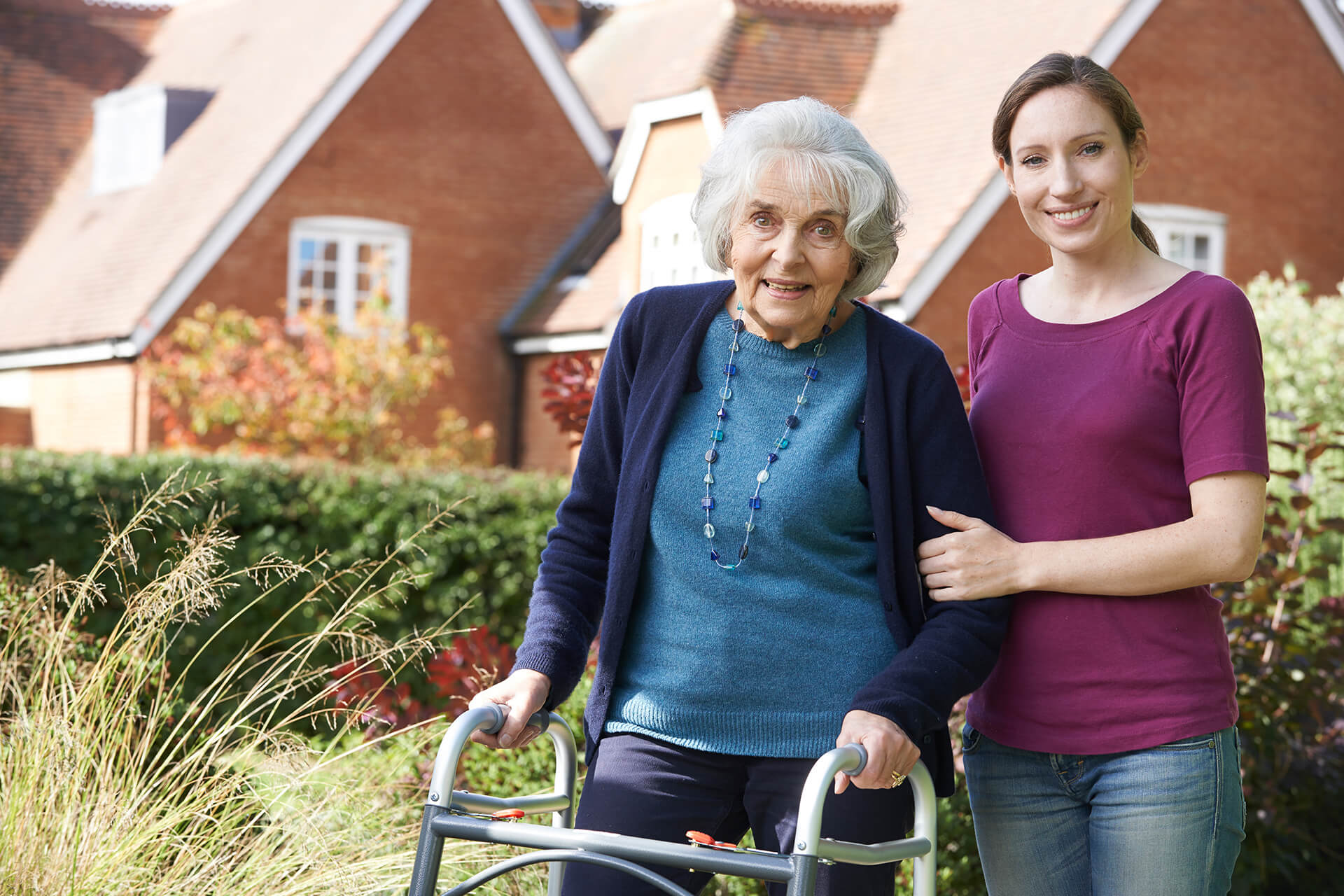 Caregiver assisting an older woman at a rehab center.