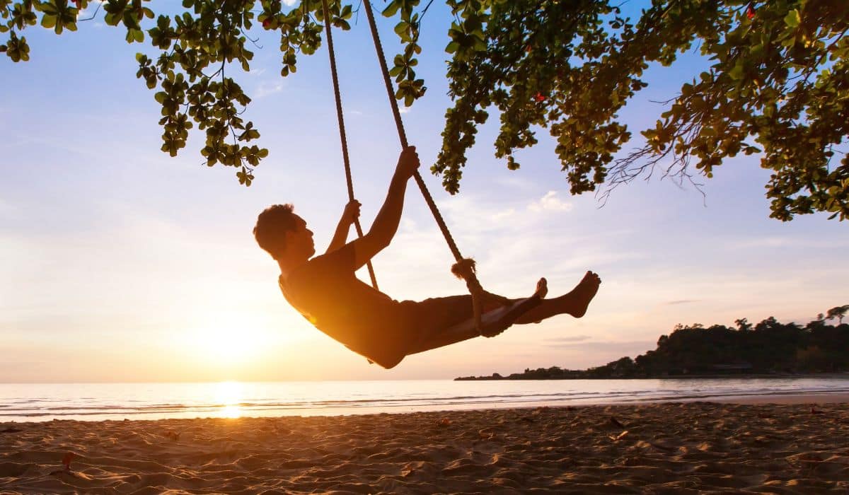 person on a swing in front of beach